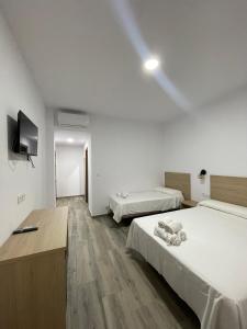 Postel nebo postele na pokoji v ubytování Hostal Malia