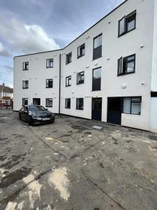 a black car parked in front of a white building at Cosy Double Room in Professional Unique Complex in London