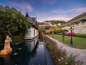 功孟海滩Sofitel Krabi Phokeethra Golf and Spa Resort的运河中间有一座雕像的房子