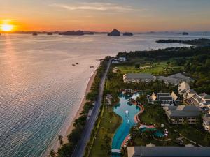 功孟海滩Sofitel Krabi Phokeethra Golf and Spa Resort的日落时度假村和海滩的鸟瞰图