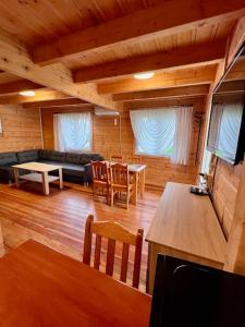 a living room with a couch and tables and chairs at Domki letniskowe Azalia in Ustronie Morskie