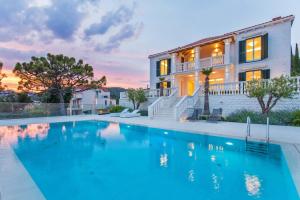 ein Swimmingpool vor einem Haus in der Unterkunft Beautiful Dubrovnik Villa 5 Bedrooms Villa Gold Dubrovnik Stylish Furnishings Wonderful Sea Views Orasac in Orasac
