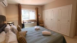 a bedroom with a bed with two towels on it at Beautiful Portuguese Villa Casa Das Buganvillas 3 Bedrooms Close To Praca Private Pool Vale Do Lobo in Vale do Lobo +25 photos