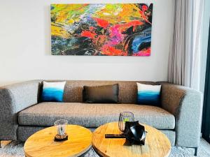 Una sala de estar con un sofá y dos mesas. en Wavescapes Surfers Lookout Stay, en Ciudad del Cabo