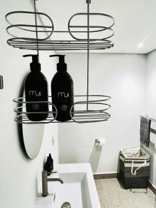 Un baño con dos botellas negras en un estante. en Wavescapes Surfers Lookout Stay, en Ciudad del Cabo 17 fotos más