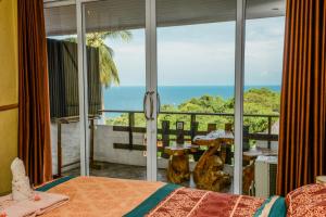 ein Schlafzimmer mit Bett und Blick auf das Meer in der Unterkunft Sairee View Resort in Ko Tao