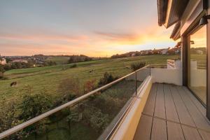 a house with a balcony with a view of a field at Ferienhaus Daheim in Sankt Peter +29 photos