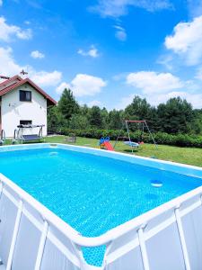 a swimming pool with a swing and a playground at Willa Panorama 881-751-206 in Polańczyk