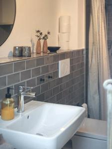 a bathroom with a white sink and a mirror at Ferienwohnung 1, Schlaf-Gut-Johannis, Flensburg in Flensburg +10 photos