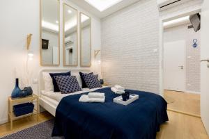 a bedroom with a large bed with a blue blanket at Stylish Studio Collection Central Budapest in Budapest