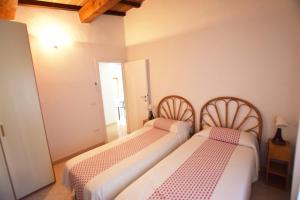 2 camas sentadas en una habitación con puerta en Villino RAMERINO, en Marina di Campo Airport
