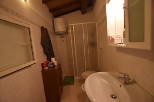 Un baño con lavabo, inodoro y espejo. en Villino RAMERINO, en Marina di Campo Airport