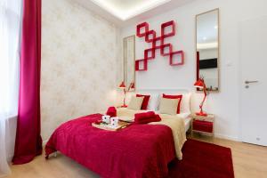 a bedroom with a large bed with a red blanket at Stylish Studio Collection Central Budapest in Budapest