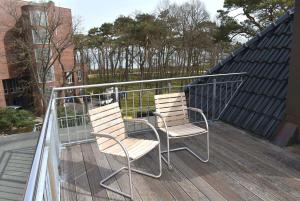 Seepassage Ferienwohnung Nr 06 في تيميندورفير ستراند: كرسيين جالسين فوق بلكونه