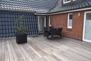 Seepassage Ferienwohnung Nr 06 في تيميندورفير ستراند: سطح خشبي مع طاولة وكراسي على المنزل