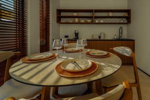 a dining room table with plates and wine glasses at Tellion Cave Villas in Agios Nikitas