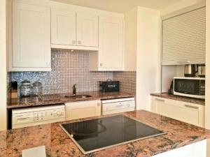 a kitchen with white cabinets and a sink at '11 Gordonia'- 2 En-suite Bedrooms, Beach access & Great location in Cape Town