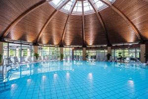 a large swimming pool with chairs in a building at Parkhotel Kurhaus in Bad Kreuznach