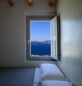 a bedroom with a window with a view of the ocean at Exquisite Santorini Villa Villa Luna 3 Bedrooms Breathtaking Sea Views And Private Pool Akrotiri in Akrotiri