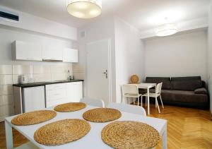 a kitchen and a living room with a table and chairs at P&J Apartments Floriańska in Kraków