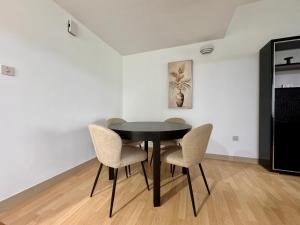 a dining room with a black table and chairs at 2 Bed Apartment in La Riviera Tower, Dubai Marina near Metro and Mall, 12-min walk to JBR Beach! in Dubai
