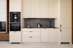 a kitchen with white cabinets and a sink at Bright Studio in Katowice with Parking, Sauna & Gym by Noclegi Renters in Katowice