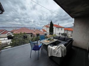 a balcony with a couch and a table and chairs at House Burić in Senj