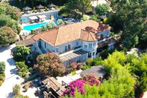 an aerial view of a house with a tiled roof at Les Jardins de Bormes, hôtel de charme et détente, espace bien-être avec sauna & jacuzzi in Bormes-les-Mimosas