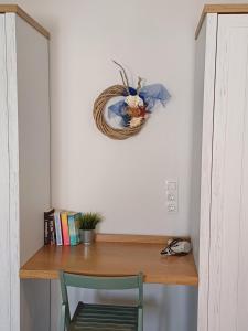 a desk with a chair and a wreath on a wall at Stella's Studio in Galissas