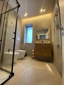 a bathroom with a tub and a sink and a toilet at B&B Cozzolino House's in Ercolano +16 photos