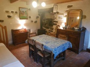 a dining room with a table and a mirror at maisonette mitoyenne in Lopérec