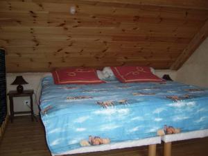 a large bed in a room with a wooden ceiling at maisonette mitoyenne in Lopérec
