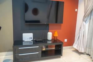 un centro di intrattenimento nero con una tv su un muro di Sky View Condo at Lennox a Trofwi