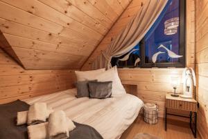 a bedroom with a bed in a log cabin at Zacisze Anioła in Łobozew