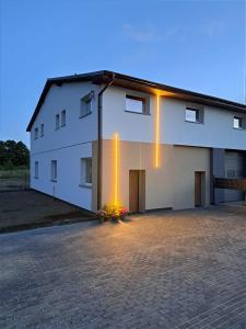 a white building with lights on the side of it at Apartamenty Wałowa 7 in Rewa