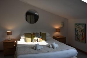 a bedroom with a large white bed with a mirror at Hôtel Restaurant Petra Cinta in Barcaggio +19 photos