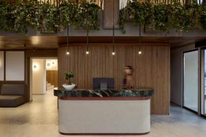 a lobby with a counter with plants above it at RoccaMare Heraklion - Handwritten Collection in Heraklio +119 photos