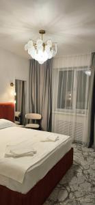 a bedroom with a bed and a chandelier at Naya Hotel in Almaty