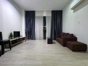 a living room with a couch and a television at Zen 66 apartment in Kuching