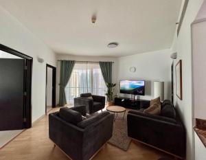 a living room with two couches and a flat screen tv at 2 Bed Apartment in La Riviera Tower, Dubai Marina near Metro and Mall, 12-min walk to JBR Beach! in Dubai +29 photos