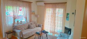 a living room with a couch and a window at Armira House in Nea Moudania