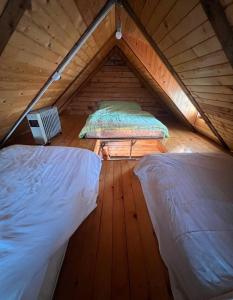 a attic with two beds in a wooden room at Kraljeva breza in Divčibare