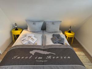 a bed in a room with two yellow tables at Bootshaus SunDeck - Strandnah in den Dünen in Wangerooge