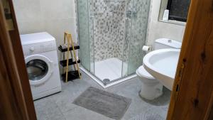 a bathroom with a washing machine and a sink at Big 7, The Paceville Stay in Paceville