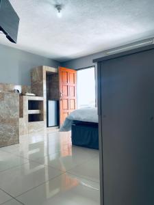 a bedroom with a bed and a door in a room at De Mose Family Lodge in KwaZibukwane