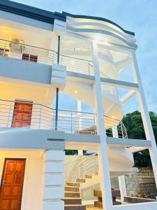 a white house with stairs in front of it at De Mose Family Lodge in KwaZibukwane