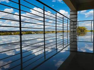 a room with a view of the water through windows at De Mose Family Lodge in KwaZibukwane +9 photos