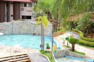 une piscine avec des palmiers dans un complexe hôtelier dans l'établissement Recanto das Águas, à Rio Quente