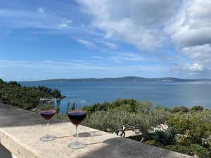 two glasses of wine sitting on a ledge overlooking the water at Villa Tramonto in Sutivan