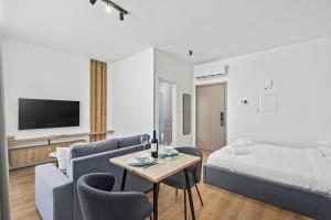 a living room with a bed and a couch and a table at Artemis 103 - Seaside Stories in Livadhia